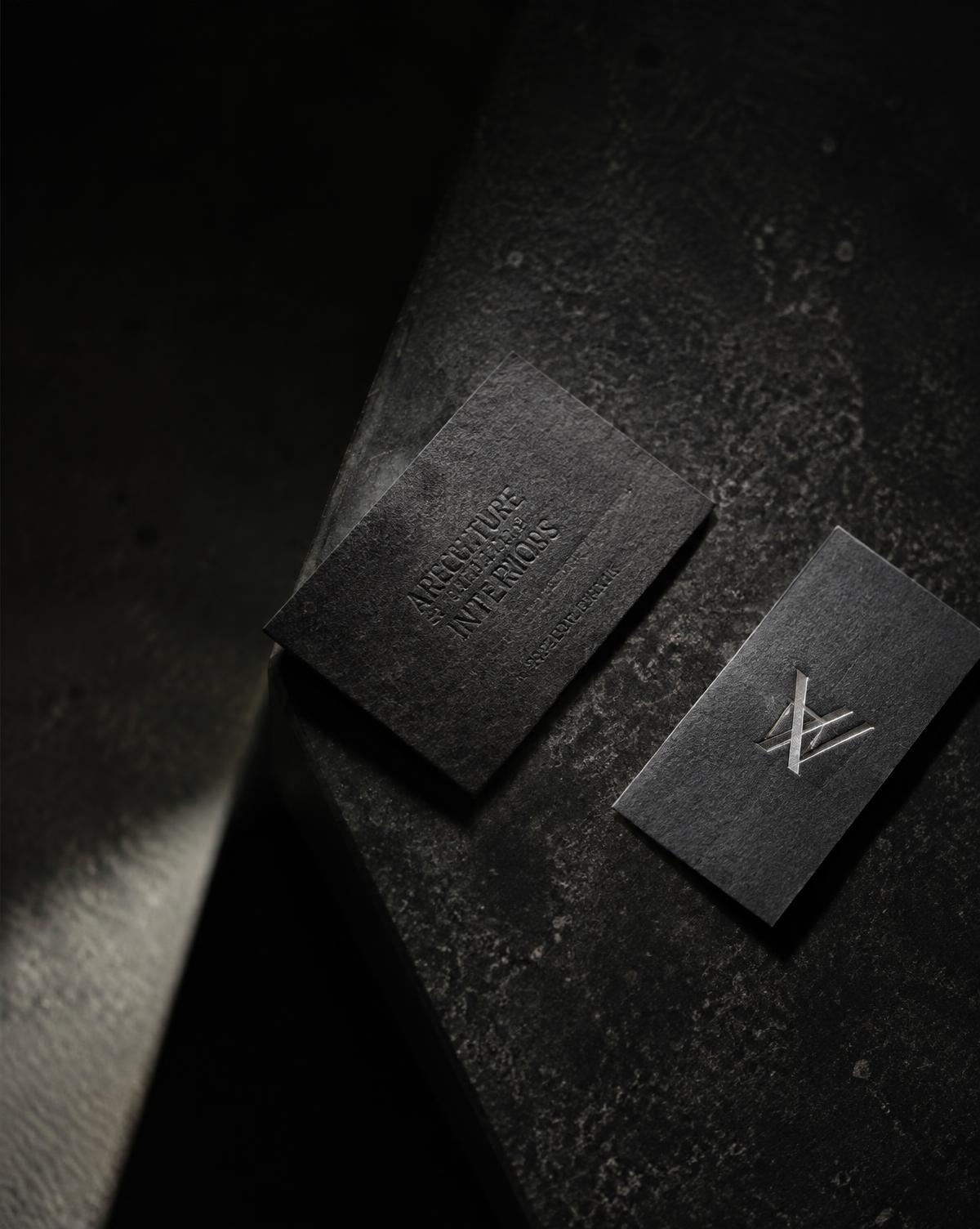 Black embossed business cards with silver monogram on charcoal stone